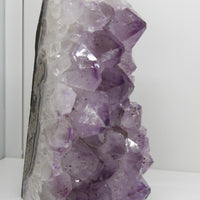 Amethyst cut base cluster showing polished edge and deep violet crystal points – natural Brazilian amethyst from Star Woman Crystals.