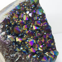 Close-up of a aura quartz crystal with iridescent colors on a white background