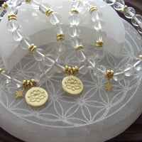 Handmade clear quartz manifestation bracelet with 18k gold-plated lotus and star charms.