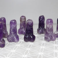Set of purple amethyst crystals on a white surface with a subtle pattern