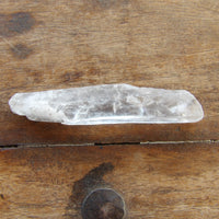 Clear quartz point on wooden surface