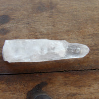 Natural crystal point on wooden background