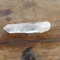Natural clear quartz point on wood