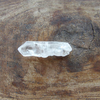 Double terminated Clear crystal on a wooden surface