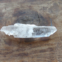 Naturally double terminated Crystal point on a wooden surface