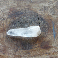 Natural Clear quartz crystal on a wooden surface