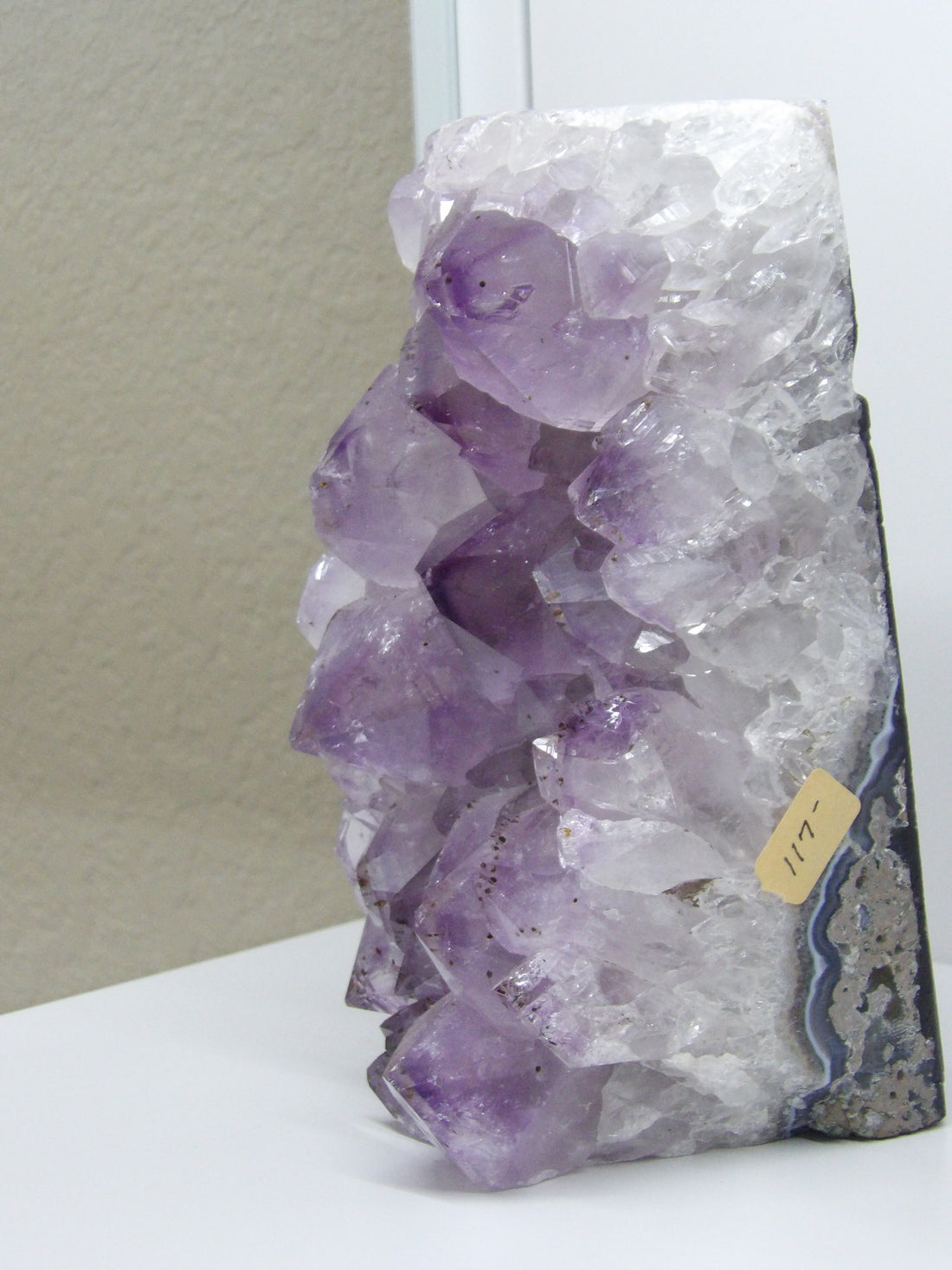 Close-up of amethyst geode face showing layered quartz and purple crystal formations, metaphysical decor for meditation spaces.
