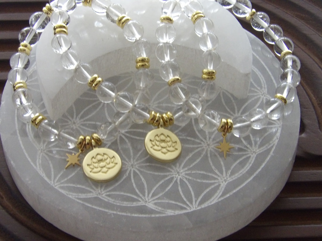 Handmade clear quartz manifestation bracelet with 18k gold-plated lotus and star charms.