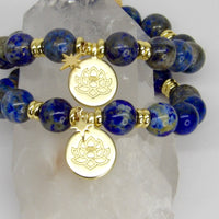 Handmade limited-edition Divine Insight Lapis Lazuli manifestation bracelets with 10mm blue gemstone beads, gold-plated spacers, lotus medallions, and star charms.