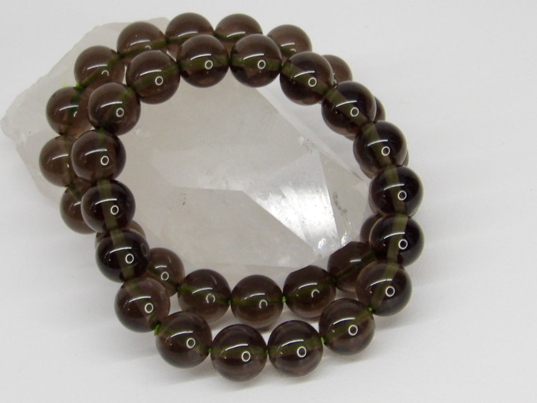 High-quality Indonesian Tektite (Agni Manitite) bracelet featuring natural 10–11mm translucent smoky olive-brown gemstone beads.