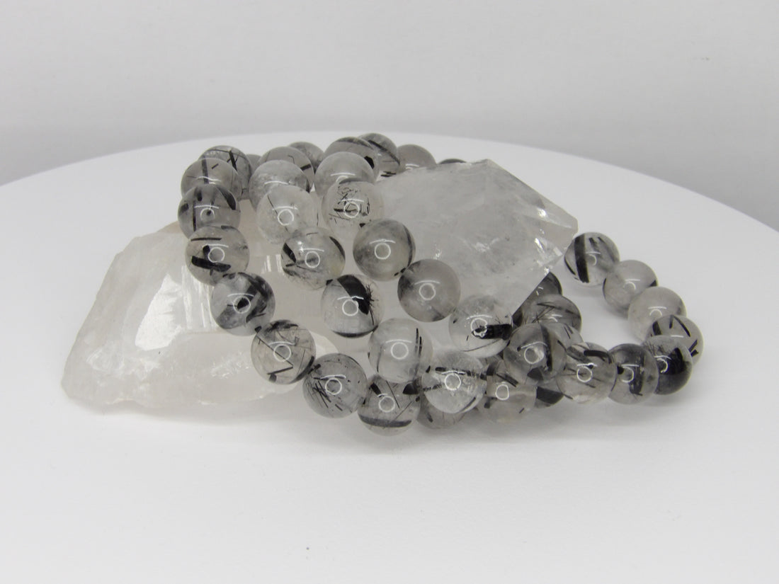 High-quality 10–11mm Tourmalinated Quartz bracelet featuring natural clear quartz beads with striking black tourmaline inclusions on a stretch cord.