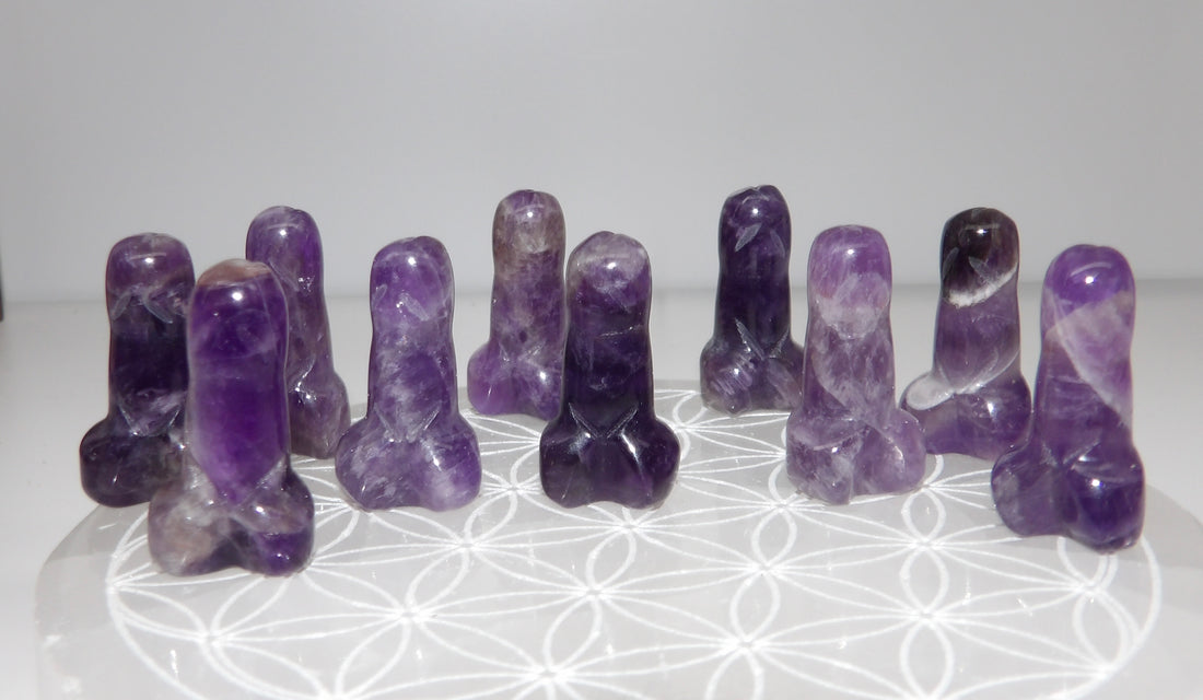 Set of purple amethyst crystals on a white surface with a subtle pattern