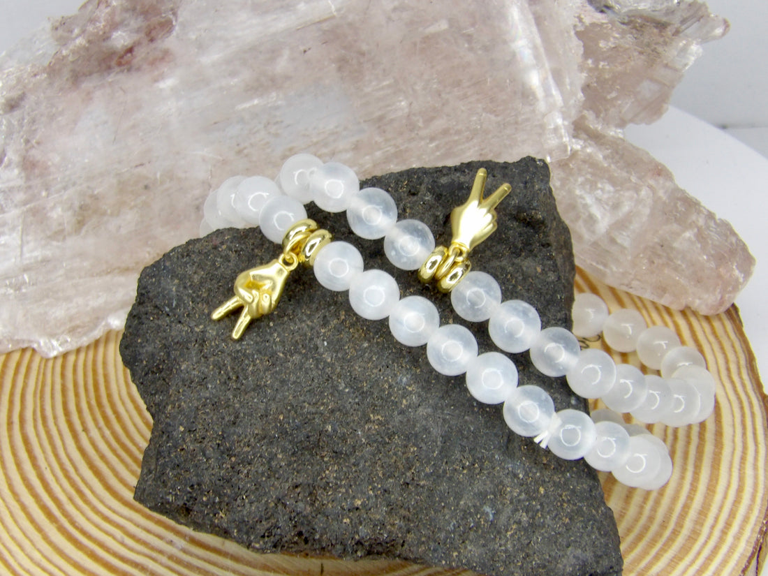 Handmade Protect Your Peace Bracelet featuring natural approximately 7 mm Selenite beads and an 18-karat gold-plated peace charm by Star Woman Crystals.