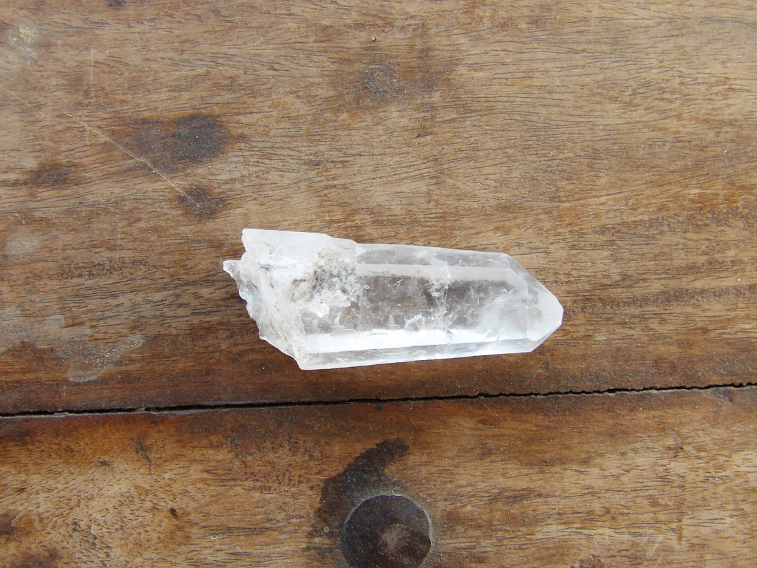 Clear crystal point on a wooden surface 