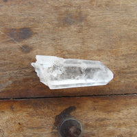 Clear crystal point on a wooden surface 