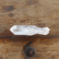 Double terminated clear quartz on wooden surface