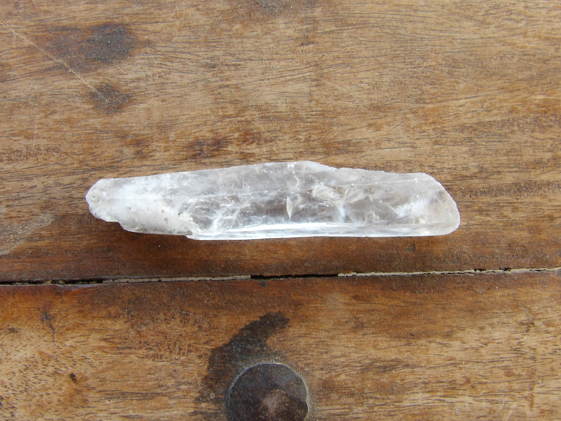 Clear quartz point on wooden surface