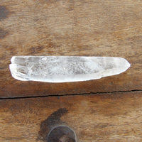 Natural clear quartz point on wooden table