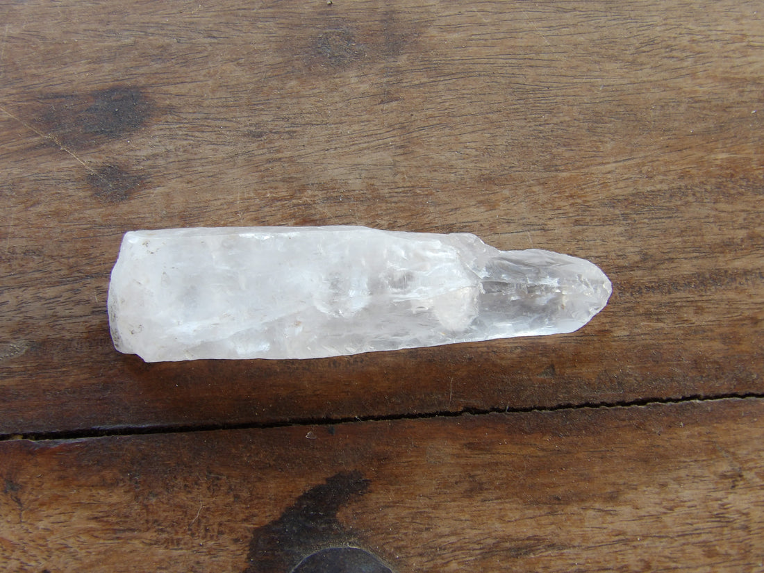 Natural crystal point on wooden background