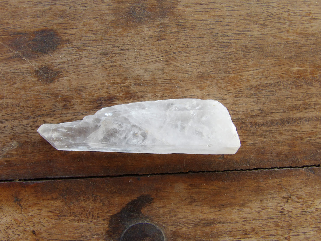 Clear quartz Crystal wand on wooden table