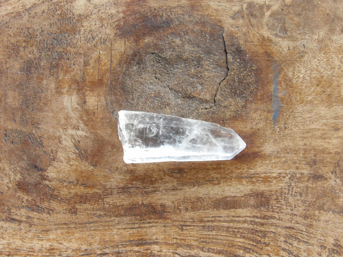 Clear crystal point on a wooden surface