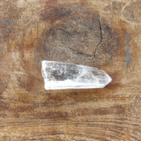Clear crystal point on a wooden surface