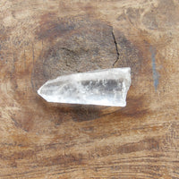 Clear crystal point on a wooden surface