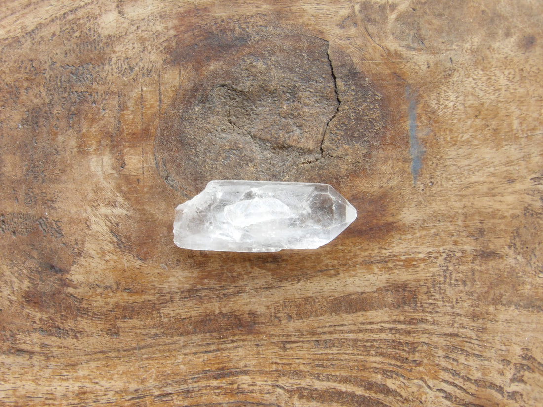 Clear quartz crystal on a wooden surface