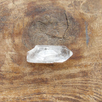Clear quartz crystal on a wooden surface