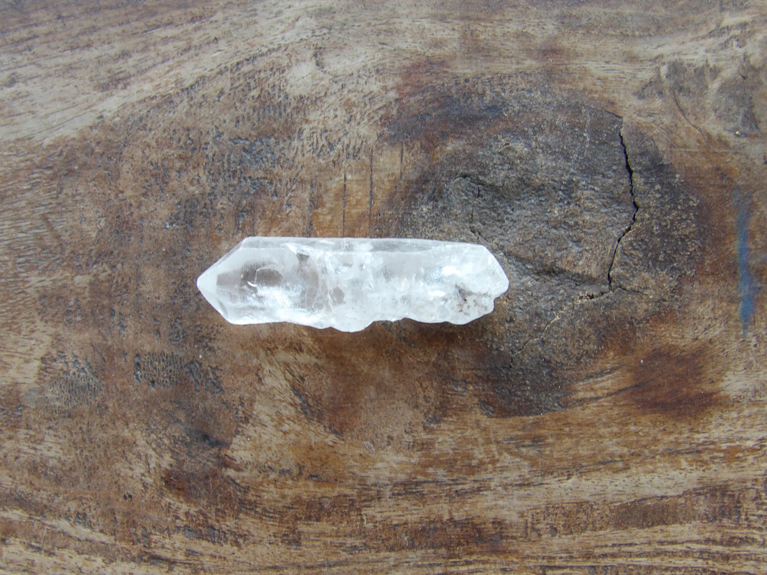 Double terminated Clear crystal on a wooden surface