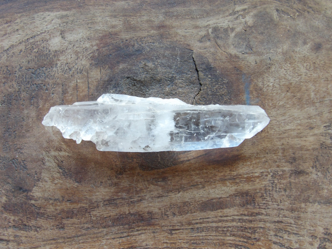 Naturally double terminated Crystal point on a wooden surface