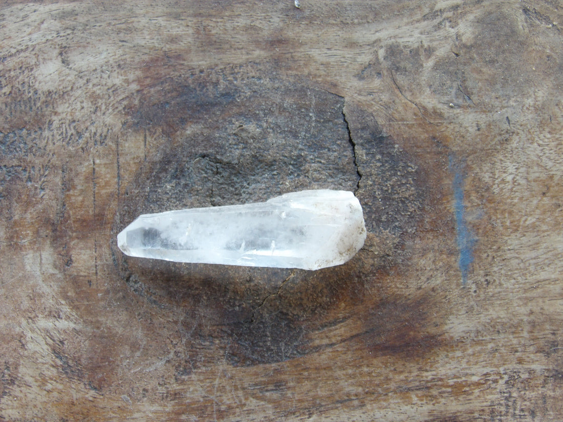 Natural Clear quartz crystal on a wooden surface