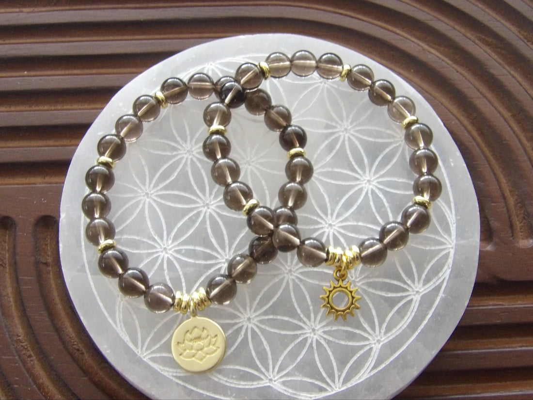 Natural smoky quartz bracelet with gold-plated lotus charm for protection and grounding energy.