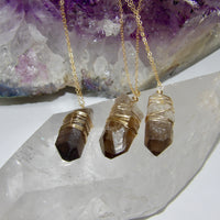 gold-wrapped smoky quartz crystal pendants on gold chains 