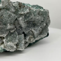 One-of-a-kind green fluorite with sparkling druzy from Nigeria featuring emerald-green crystal faces, natural white mineral vein, and UV-reactive crystals.